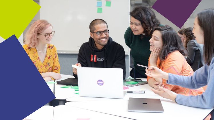 group of students discussing and looking at laptop