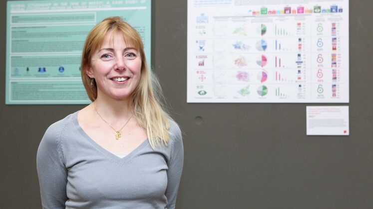 Nathalie Cornee smiling and looking at camera in front of posters from the 2020 LSE Research Festival.