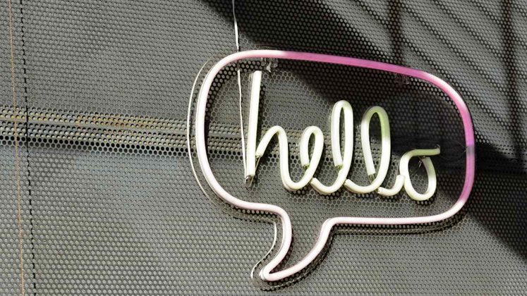 A sign on a wall outside that reads 'hello'.