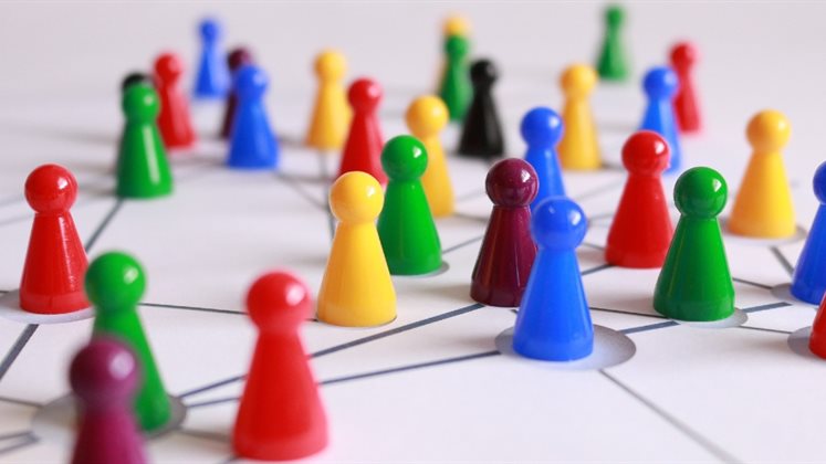 Multi-coloured board games pieces arranged on a board to represent networks