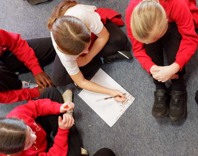 Children sat around on the floor working together
