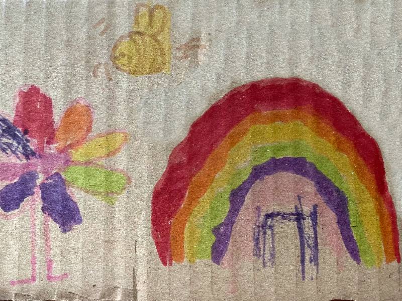A child's drawing of a rainbow, a bee and a flower.