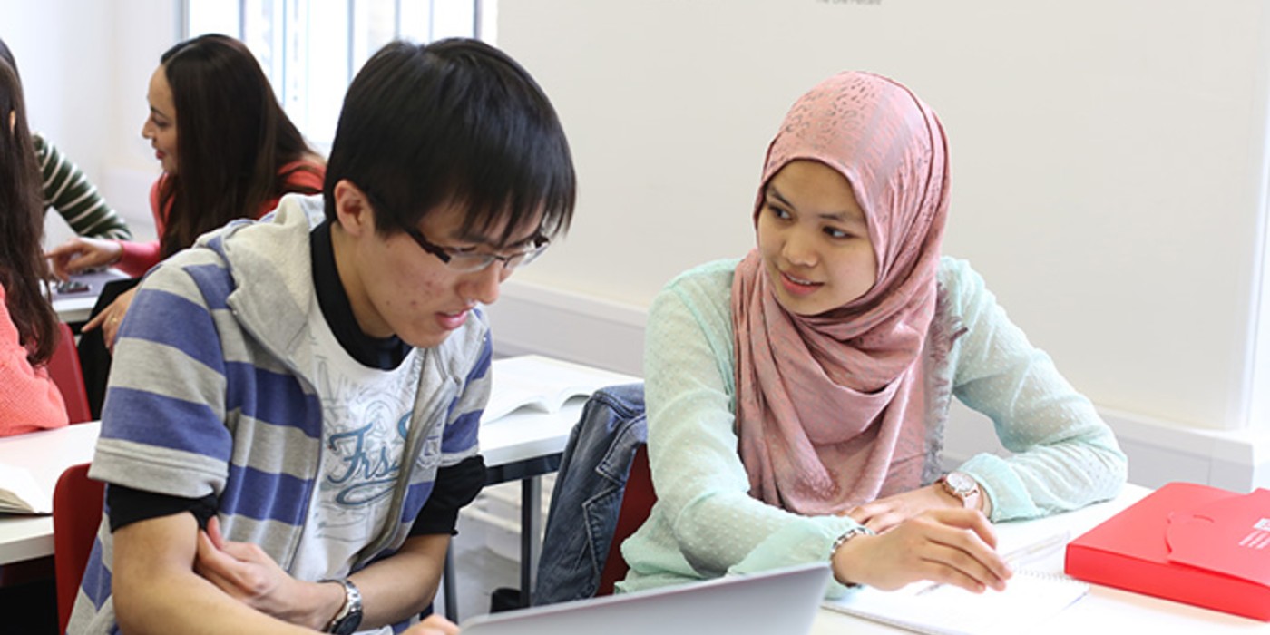 Two students, one male and one female, working together at a desk.