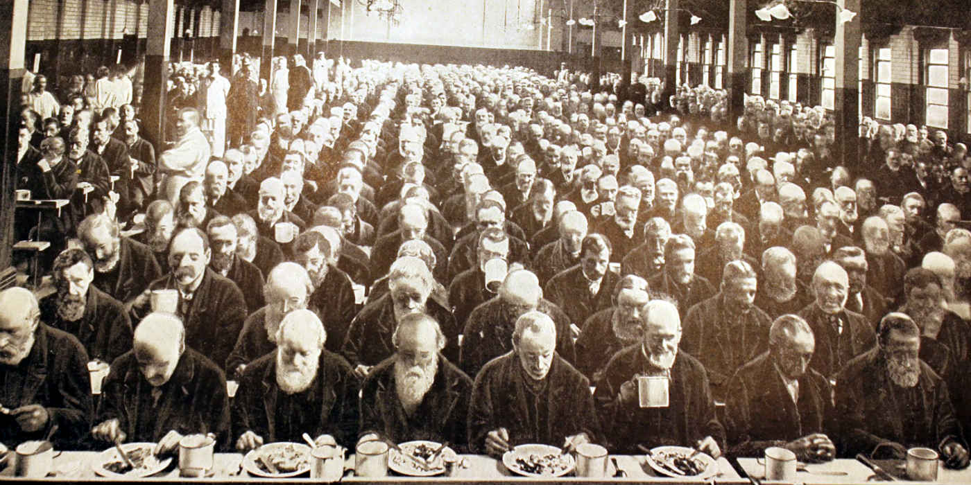 Workhouse dinner with lots of men lined up eating.