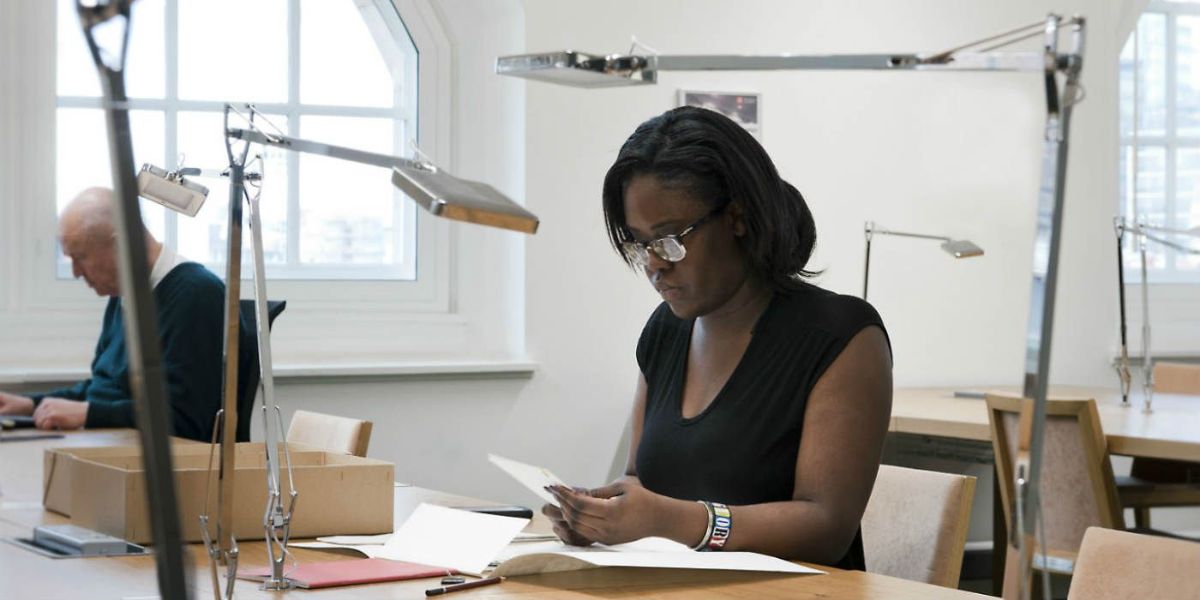 Two people sat in the reading room working with documents