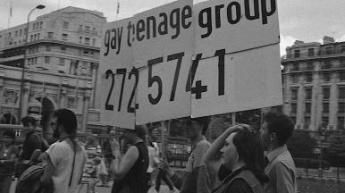 A group of protestors with a gay teenage group banner