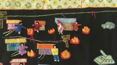 Chilean embroidery. Includes people and homes and flames.
