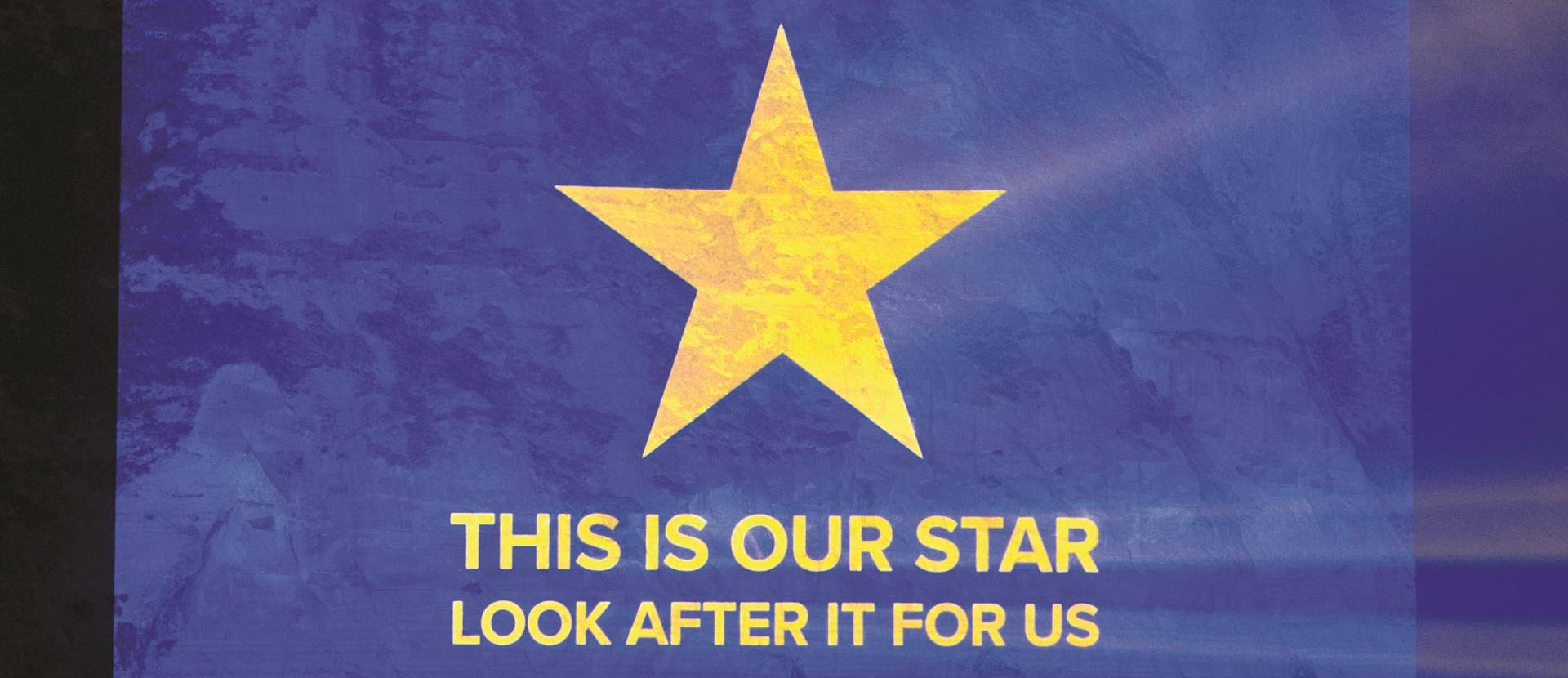 A gold star on a blue background above the text "This is our star, look after it for us".