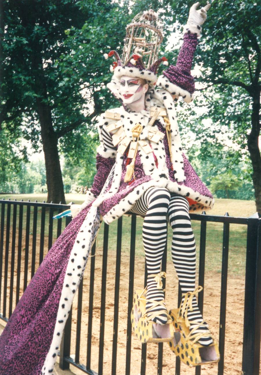 A person in a intricate costume sat on a fence