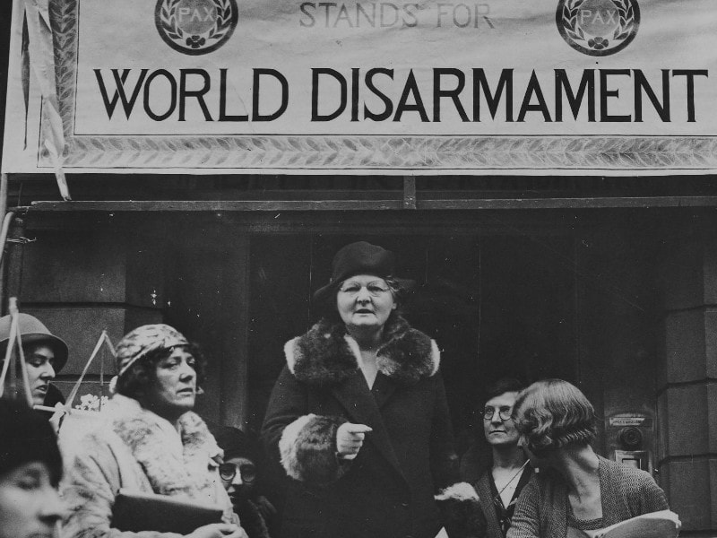 Margaret Bondfield giving a talk in front of a banner