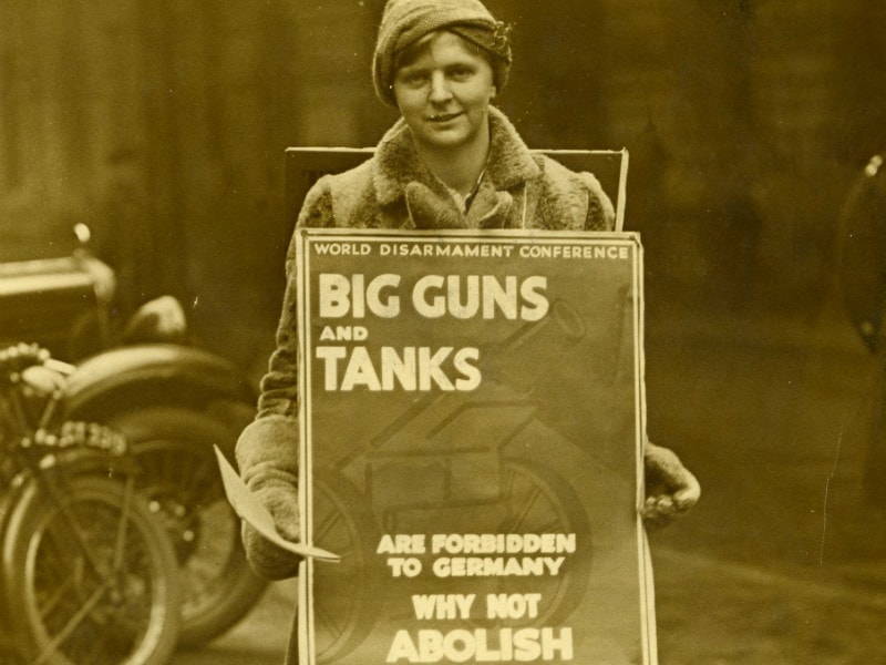 Woman with abolish weapons board