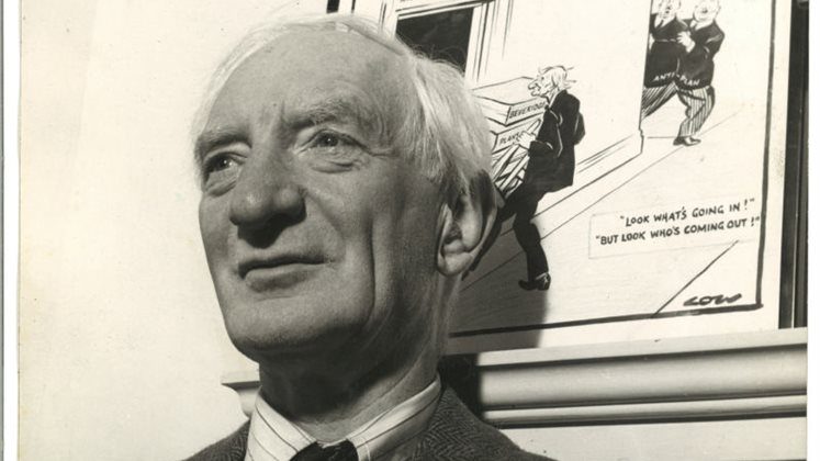 Lord Beveridge standing up against a wall and looking into the distance