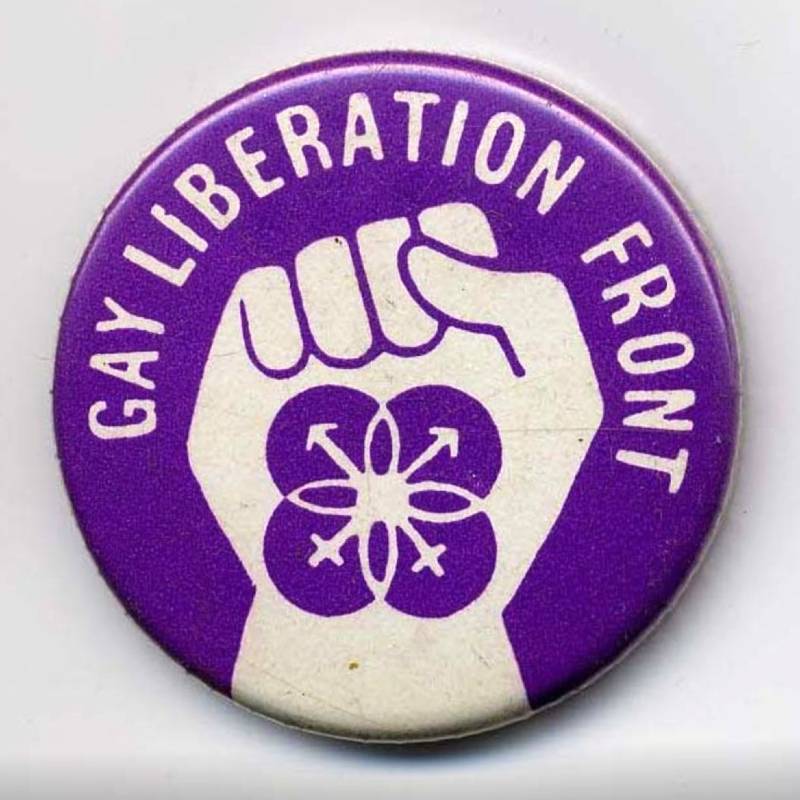 A Gay Liberation Front badge. Purple. Shows a clenched fist