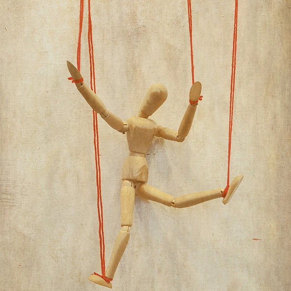 Image of a wooden doll bound by the hands and feet