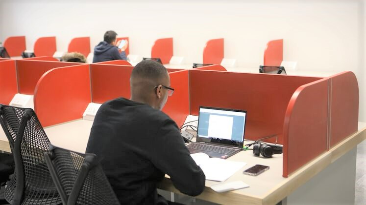 student studying in LSE Library with laptop and text book