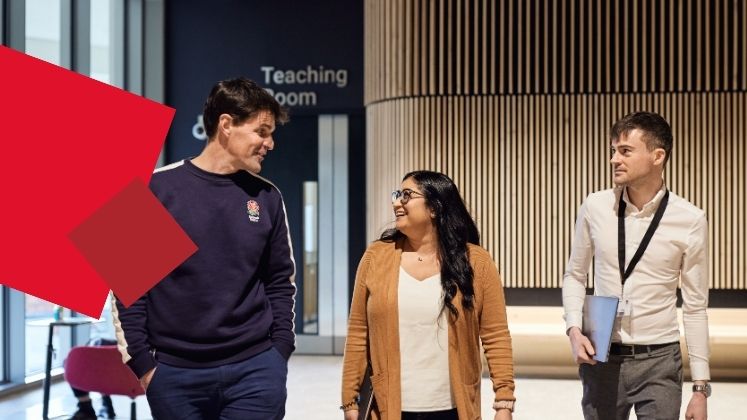 Group of students walking and smiling in the Marshall Building.