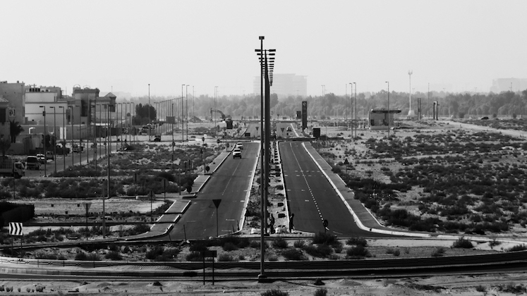 Black and white photo of a suburban collector road in Shakhbout City, Abu Dhabi.