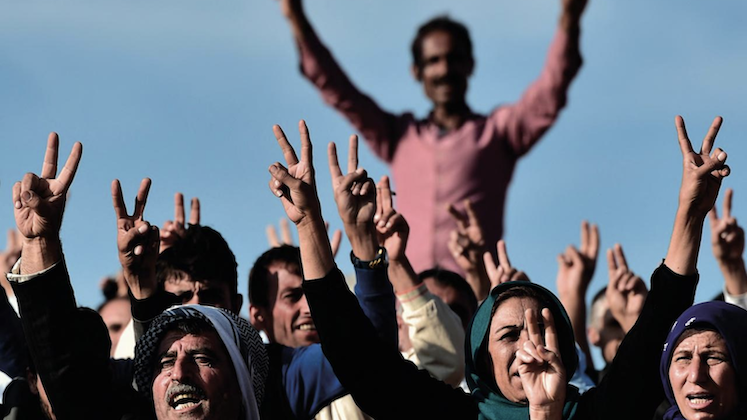 A group of Kurdish people giving the victory sign
