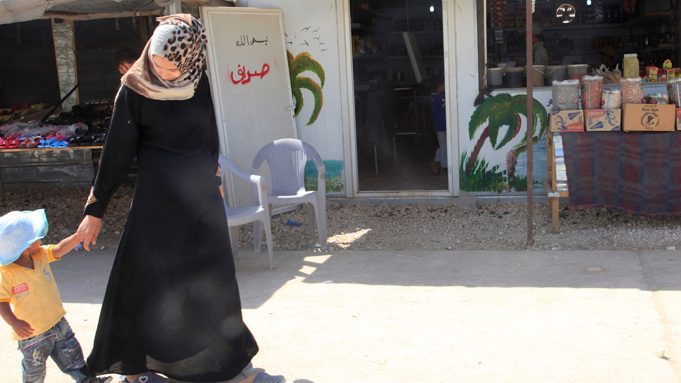 Syrian refugee woman and child walking in a camp in Jordan