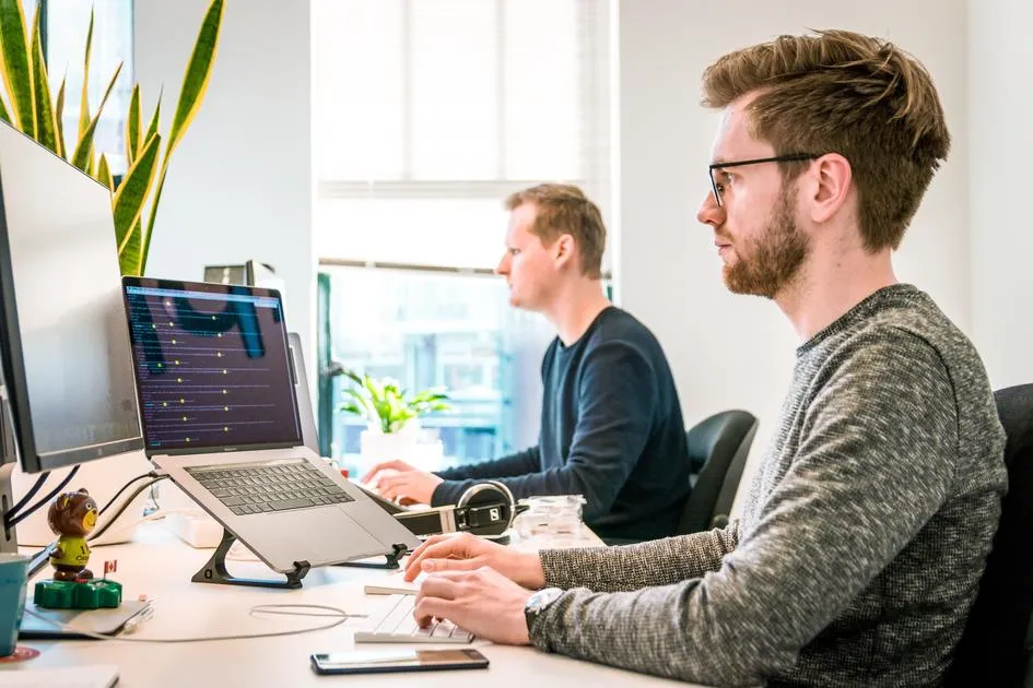 Two men working at laptops