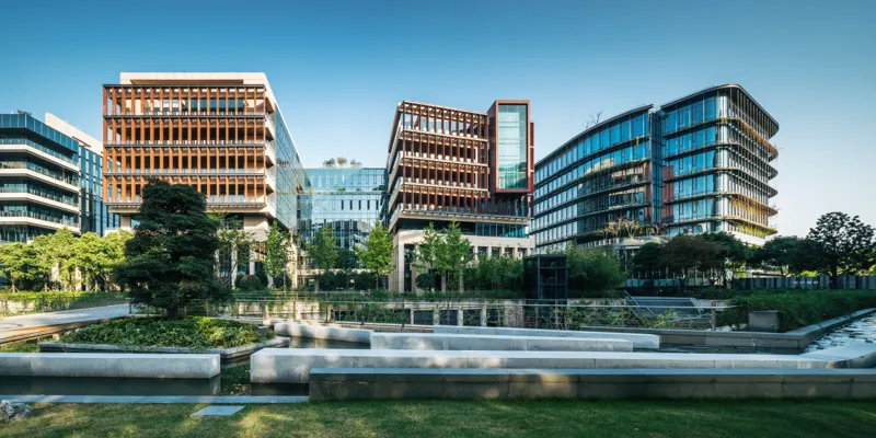 Three buildings with lake and trees in front Sustainability: Environment, Economy and Society