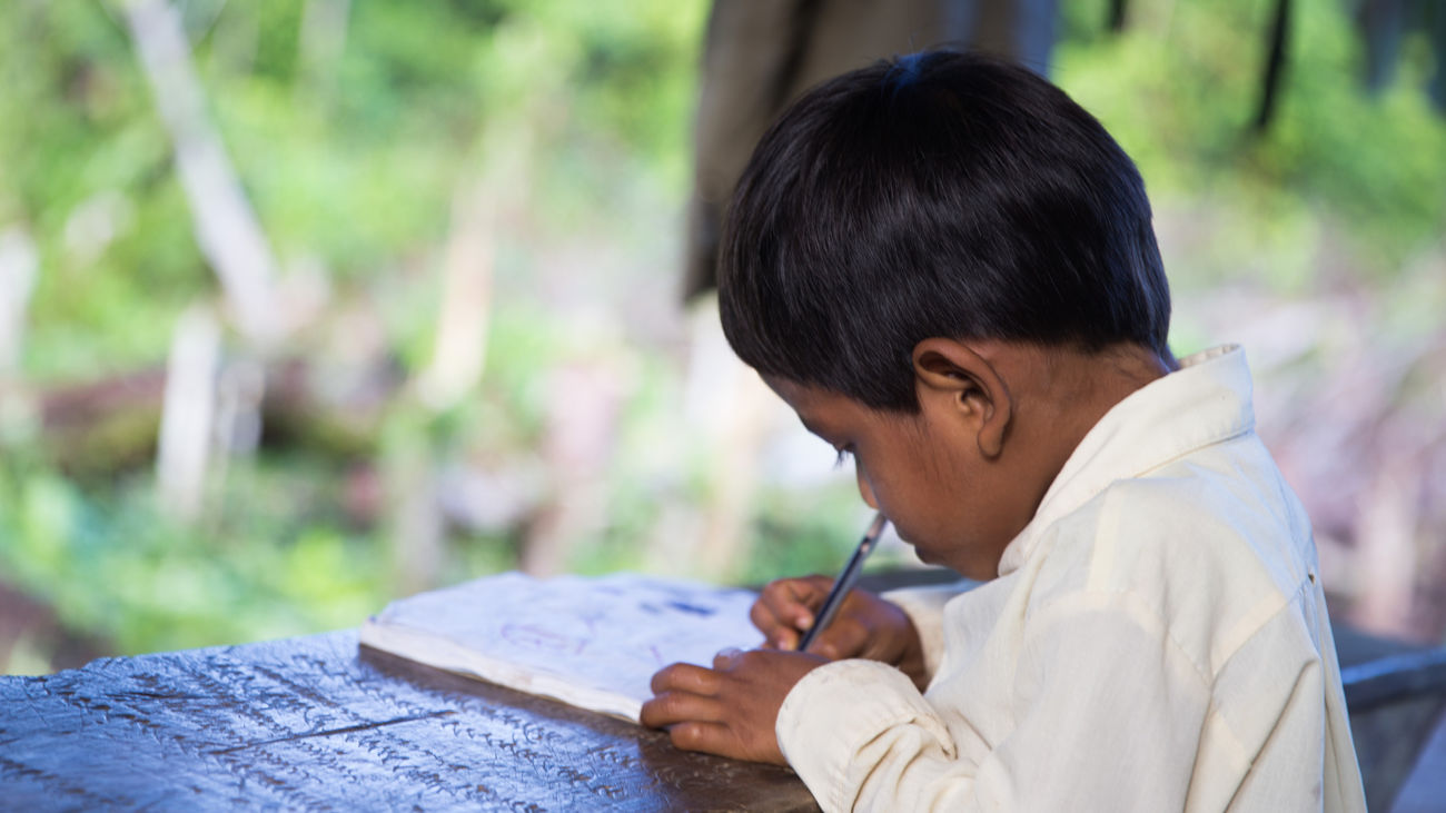 An Urarina boy writing 