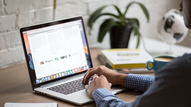 A man typing on a laptop on a desk