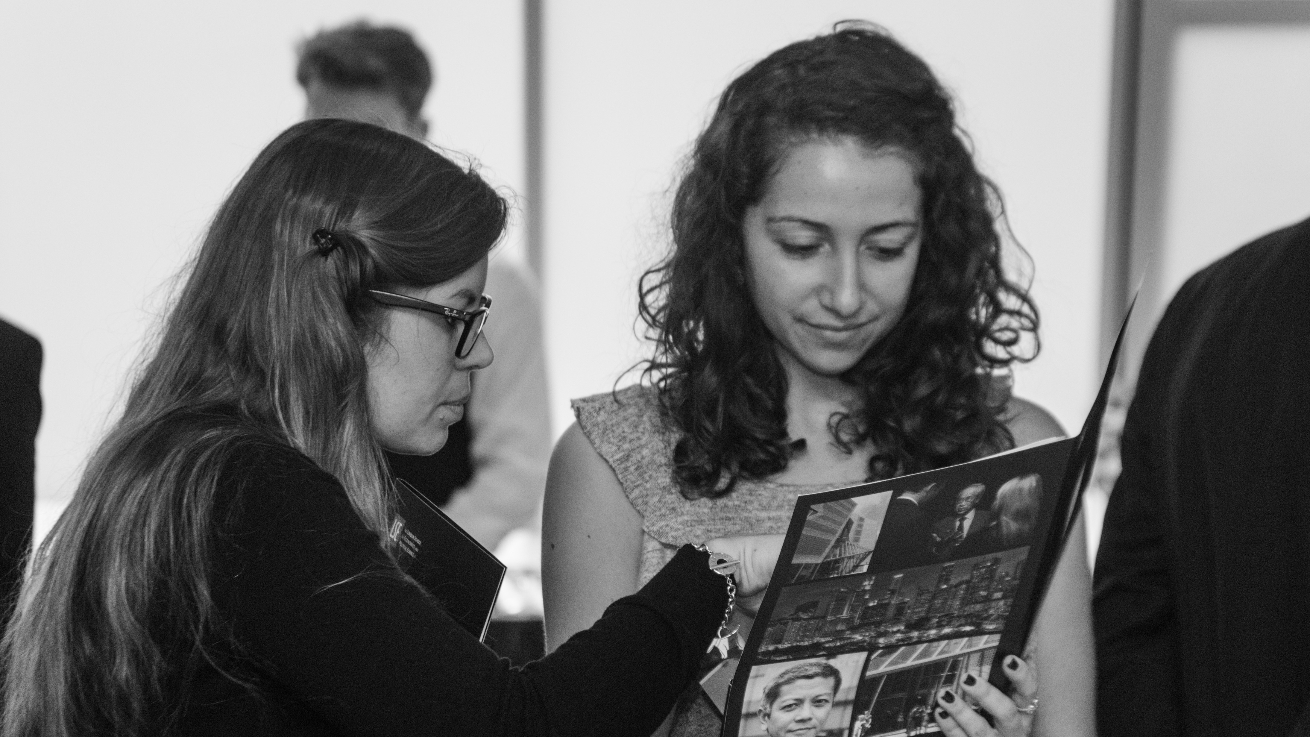 Two women examining an LSE SEAC conference pack