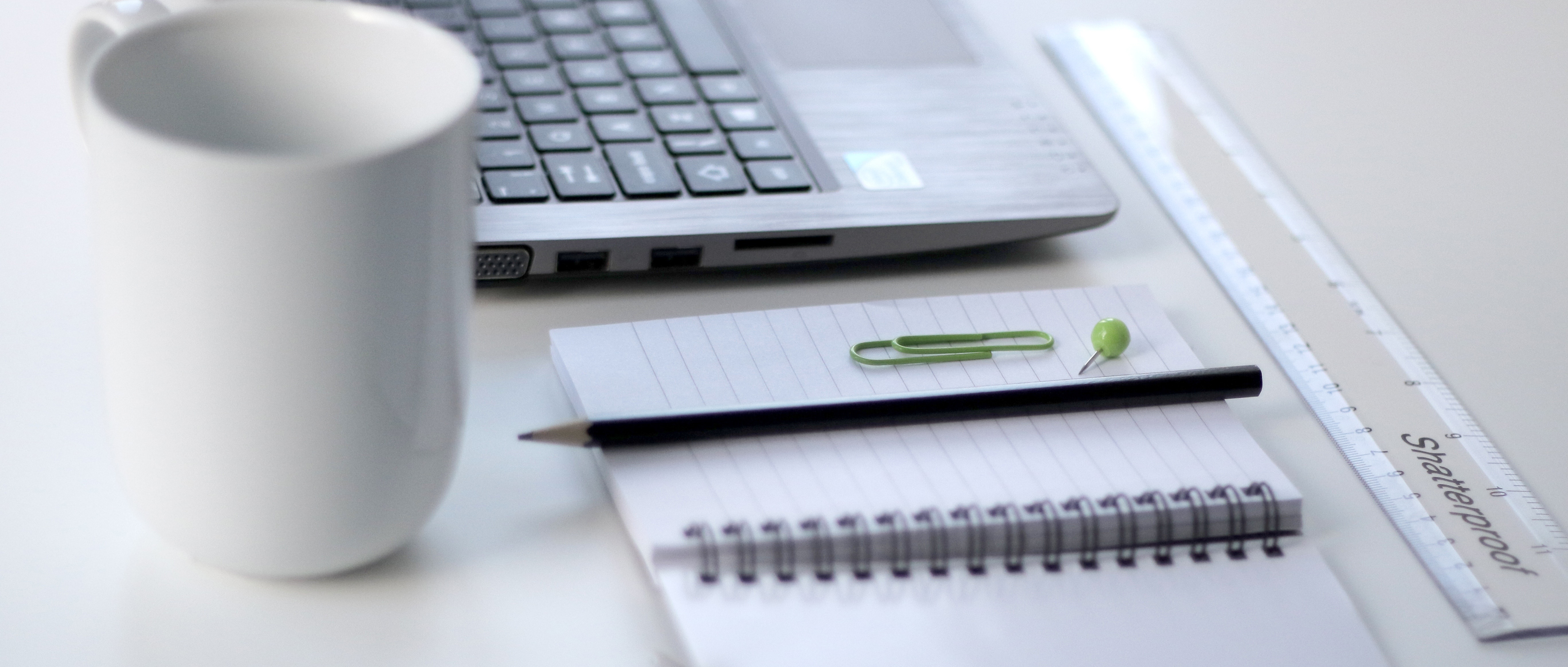 A mug, a laptop, and stationary on a desk