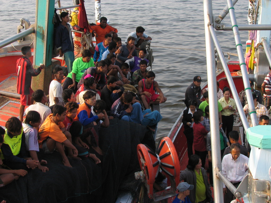 Refugees aboard two boats next to each other at sea