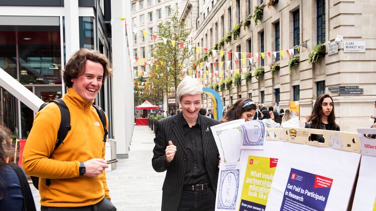 Two people stood looking at research posters in LSE's Plaza.