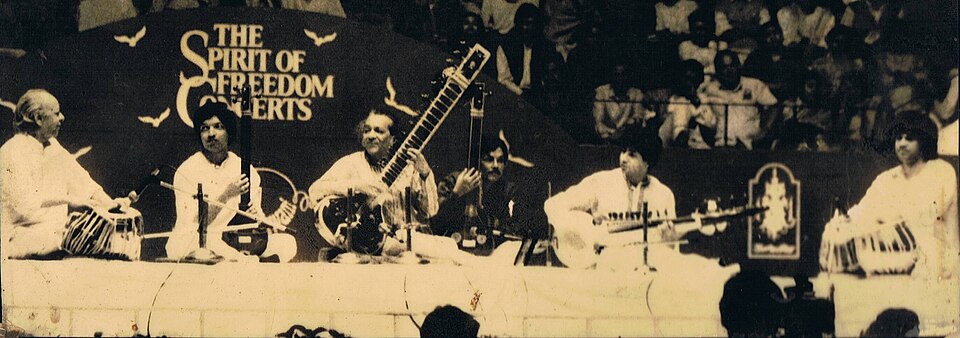 Ravi_Shankar_with_Allarakha_&_Zakir_Hussain_&_Partho_Sarothy_(cropped)