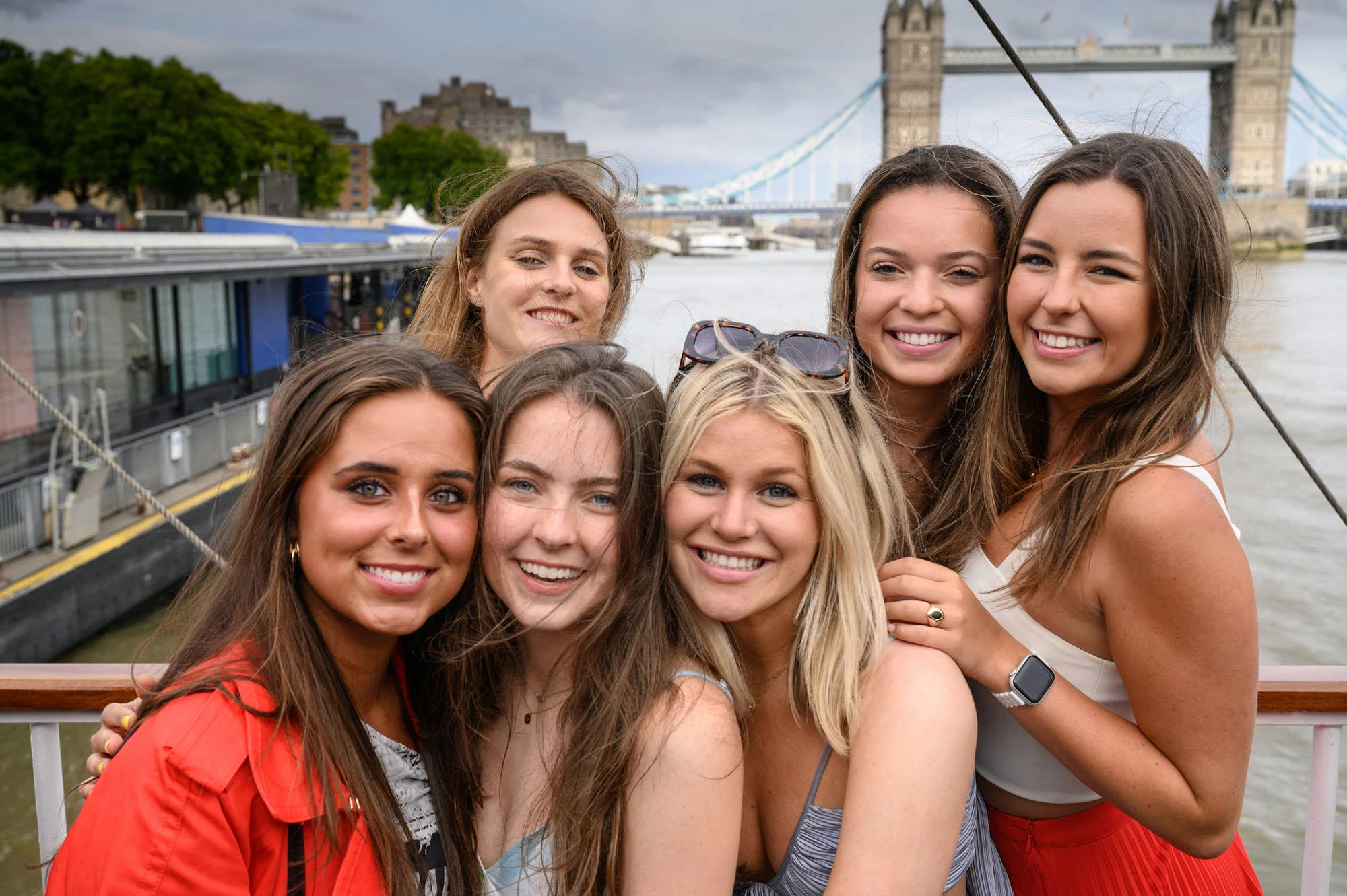 Girls posing on boat in front of Tower Bridge