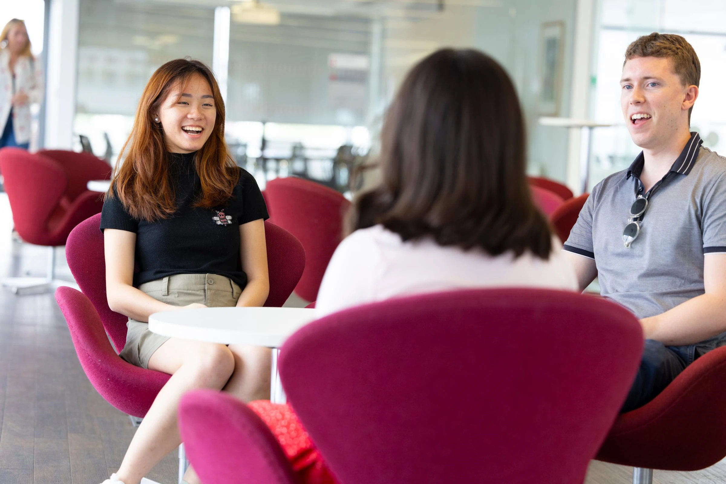 students smiling in a group round a table