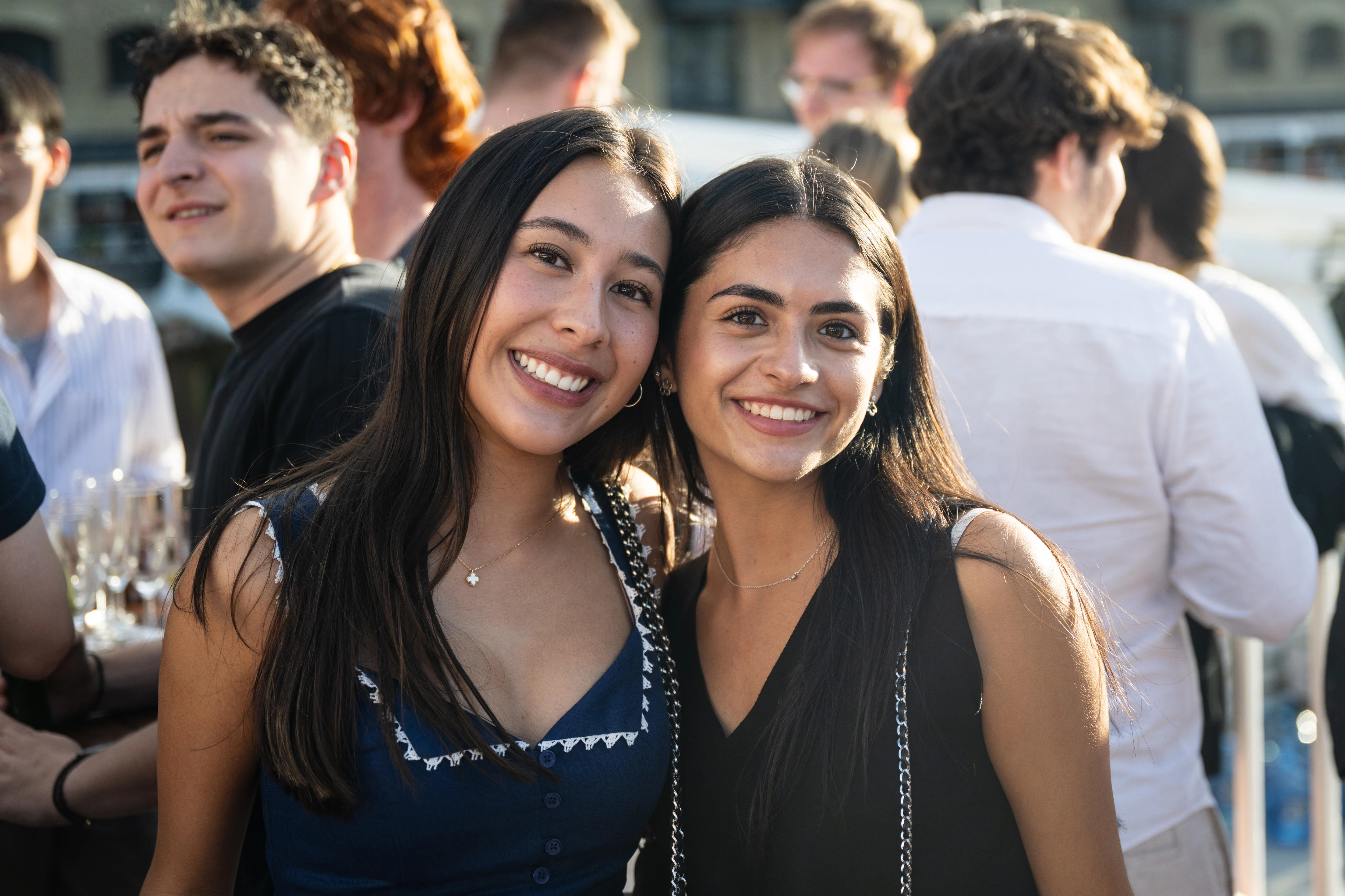Two girls in a crowd in the evening sun